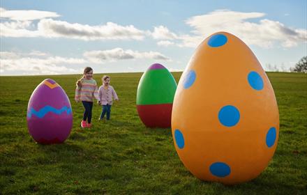 Children play around some giant Easter eggs