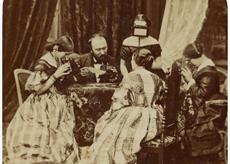 Victorian family examining stereoscopes around a table