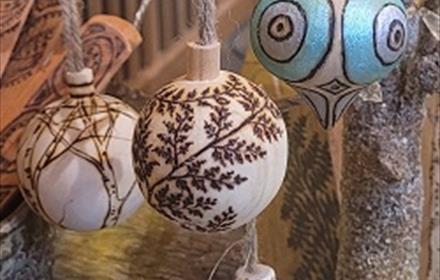 A selection of wooden baubles with patterns painted and burnt onto them