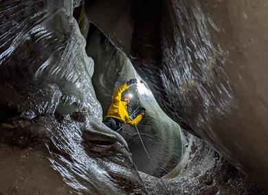 A person climbing inside an ice cave