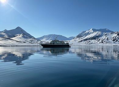 Boat in the ocean in front of Arctic landscape