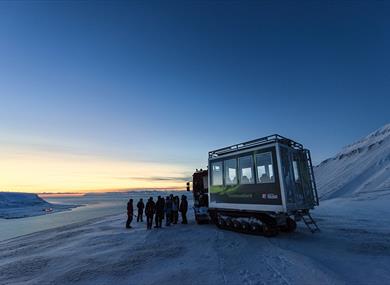 People standing in front of a snowcat