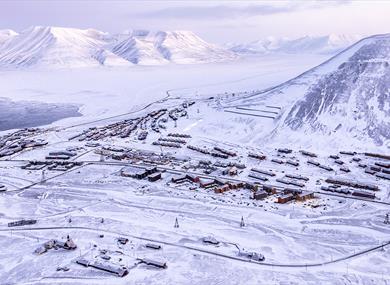 Longyearbyen and nearby mountains seen from above during winter