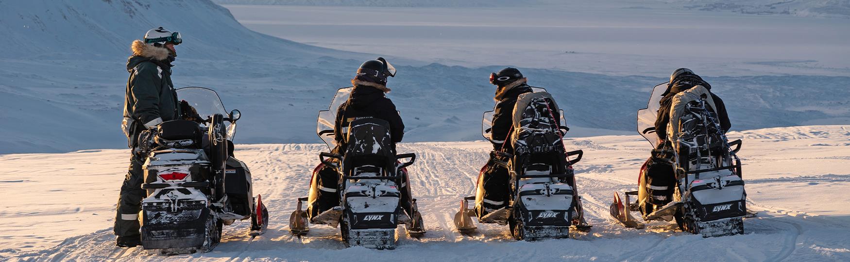 Fire personer på snøscootere