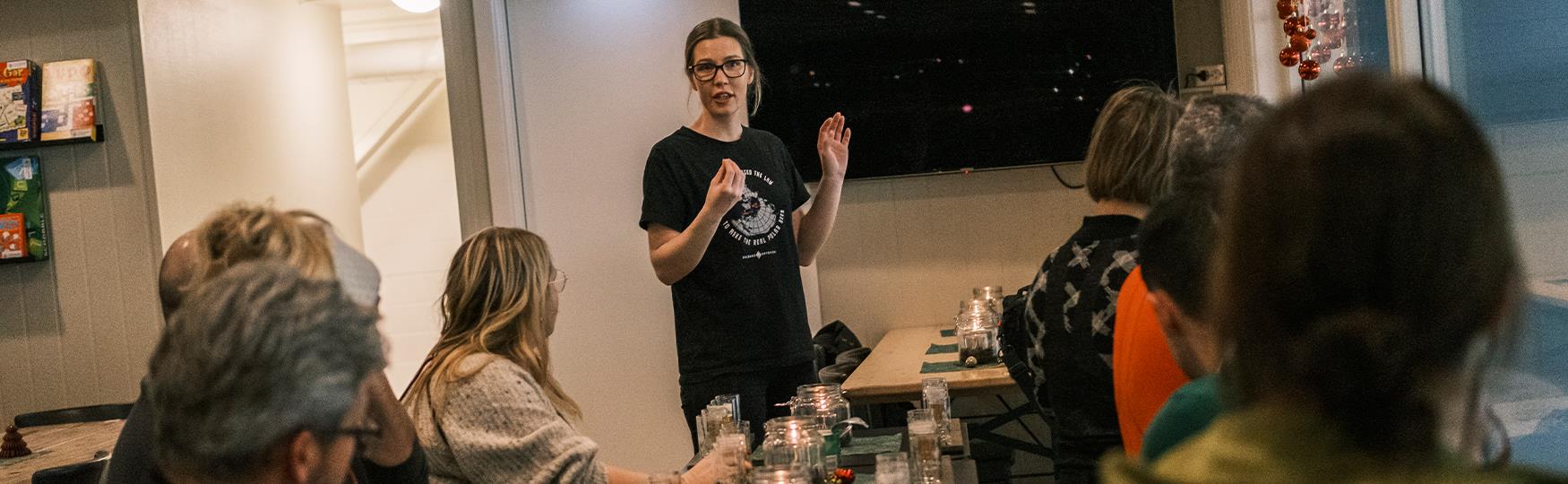 A host arranging a brewery visit looking towards a group of guests