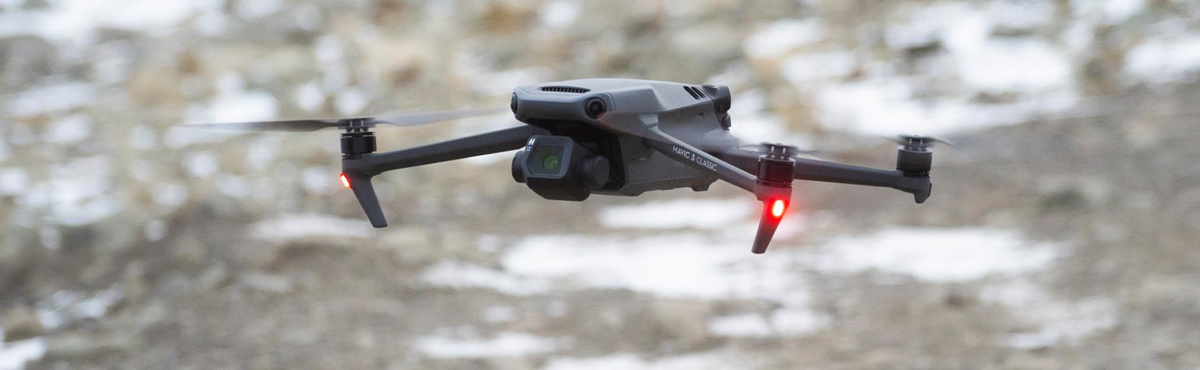 En drone som svever like over bakken