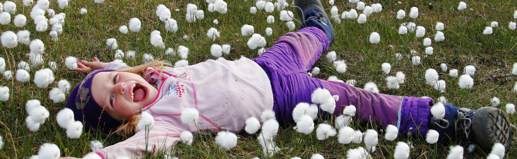 A child laying in a meadow, Photo: Green Dog Svalbard