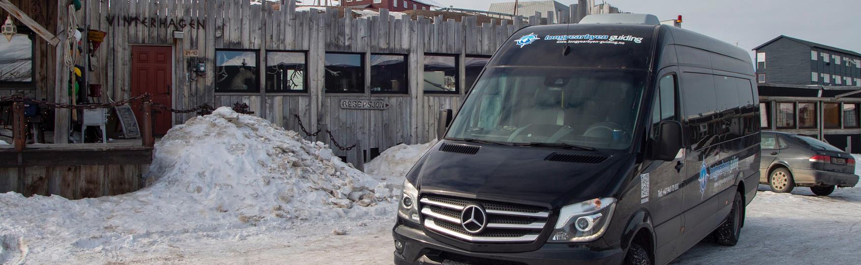 A mini bus parked in front of a building