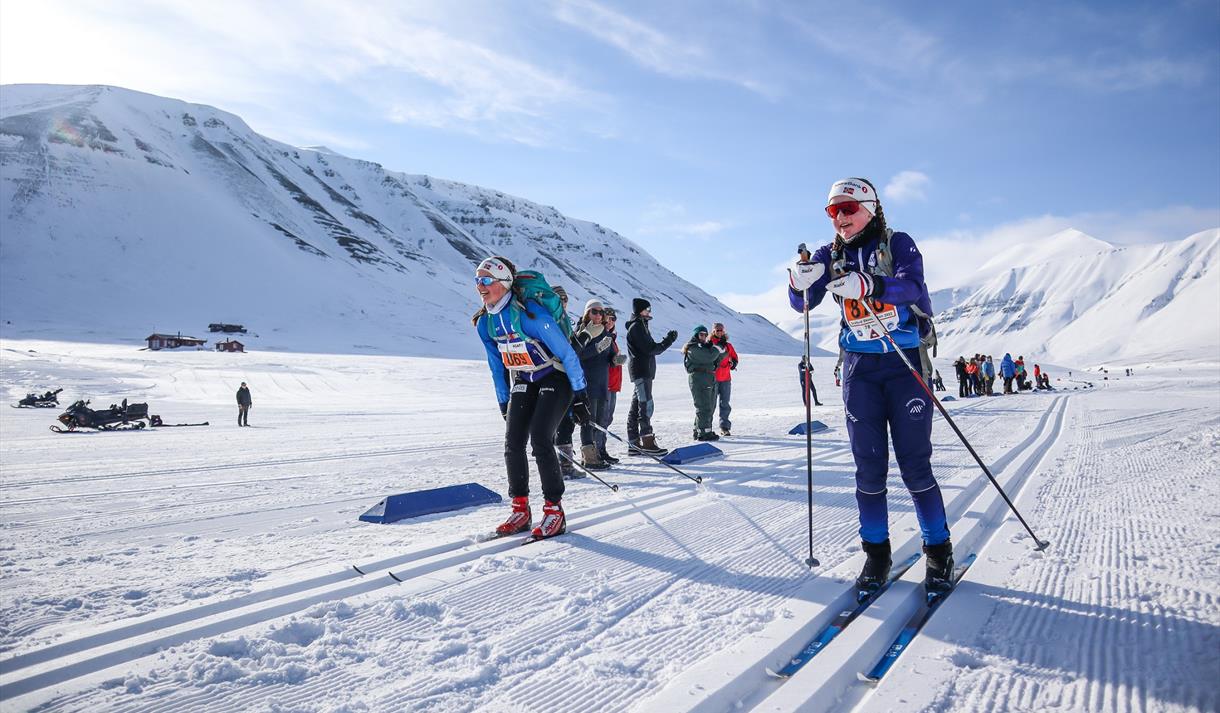Deltakere på Svalbard Skimaraton som staker forbi tilskuere i løypa