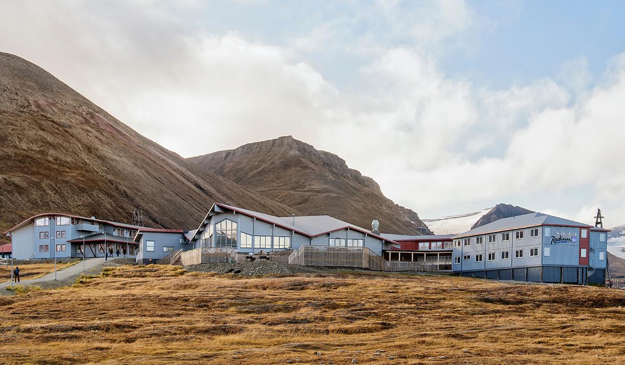 Hotellet Radisson Blu Polar Hotel sett utenfra med fjell i bakgrunnen