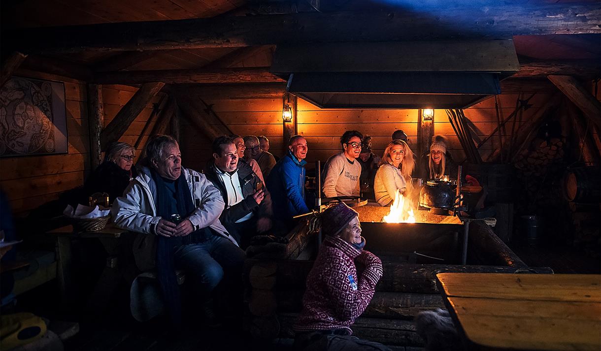 Gjester som følger med på et foredrag inne i hytta på Camp Barentz