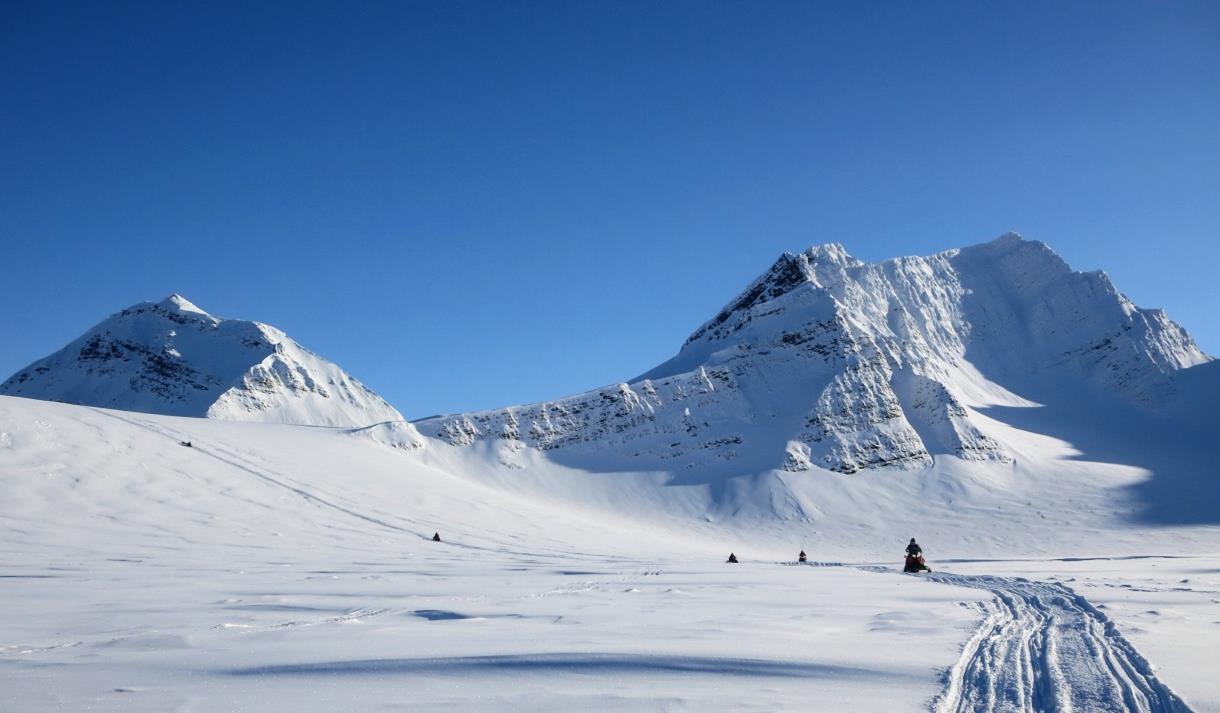 Turgruppe som kjører snøscootere