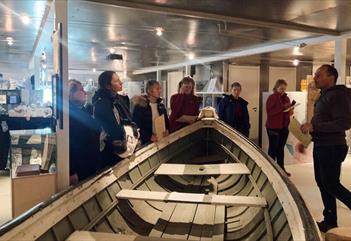 A guide and a group of guests on a guided tour in between the museum's exhibitions