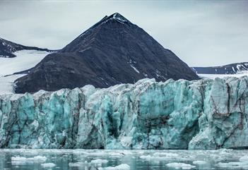 Floating ice in a fjord with glacial walls rising up towards the mountains