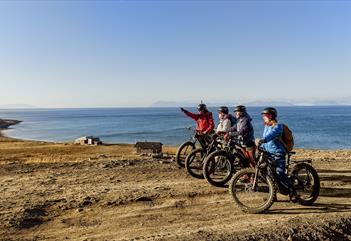 A guide and guests on bikes taking a break to look at the nature around them