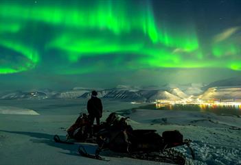 Nordlys under et frossent fossefall - med snøscooter - Snowfox Travel