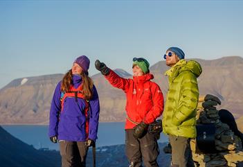 Tre personer på toppen av et fjell