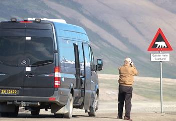 Guest taking picture of the polarbearsign in Adventdalen