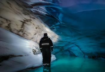 Person står inne i den blå isgrotta