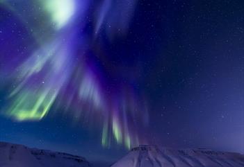 Blue and purple northern lights above the mountains