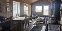 The living room and kitchen with seating and tables inside the wilderness cabin Reinheim