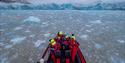 Guest on board a boat sailing in between chunks of ice floating in the water