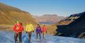 Four persons hiking up a glacier