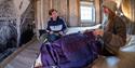 Two guests sitting on two beds inside a bedroom at Tommy's Lodge