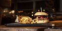 A burger with chips served on a table