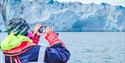 A person taking photos of a glacier