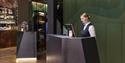 A receptionist working on a computer in a hotel reception