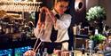 A bartender mixing a drink behind a bar