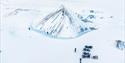 Pyramideformet isberg midt i et hvitt og snødekt landskap