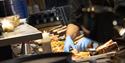 A chef behind a counter preparing dinner plates with seafood