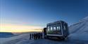 People standing in front of a snowcat