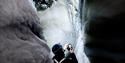 person taking pictures of the ice, inside an icecave