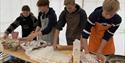 Local youth making food on a table in the food tent