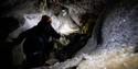 Person climbing inside of an ice cave