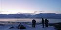 Five people looking towards Longyearbyen and the beautiful light over the city.
