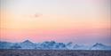 Colourful skies above a fjord and a mountain range