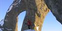 A person standing underneath a mountain formation called Tarantellen / The Tarantula