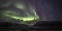 Northern lights shining above mountains