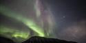 Northern lights shining above a mountain