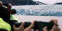 Picture of passengers photographing a glacier in the background