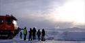 People standing next to a snowcat