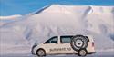 A car with snowy mountains in the background