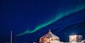 A strip of northern lights shining above Camp Barentz