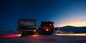 A snowcat out in the field with Longyearbyen in the background