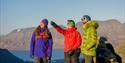 Three persons on top of a mountain