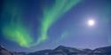 Northern lights over snow covered mountains